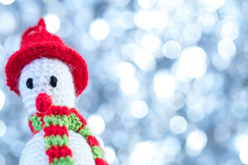 Knitted snowman from close range on a snow background. Christmas cards.