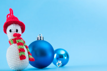 Knitted snowman on a blue background with the bank. Christmas cards.