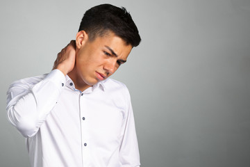 Fototapeta premium Frustrated young man in shirt massaging his neck
