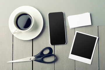 smartphone beside of coffee on wooden table.