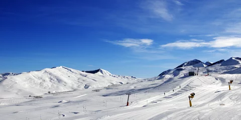 Fotobehang Panoramic view on ski slope with snowmaking at sun day © BSANI