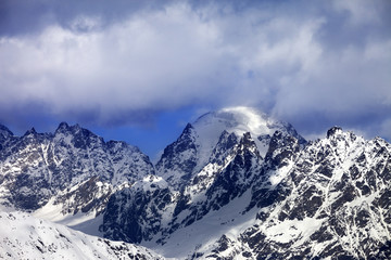 Fototapeta premium Snow mountaims in clouds at sunny winter day