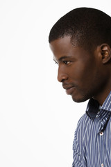 Closeup portrait of Afro-American man looking away while posing over white background in studio. Studio shot.