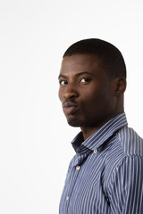 Obraz premium Portrait of Afro-American businessman looking at camera in studio. Handsome man in blue shirt posing for photographer isolated on white background.