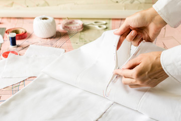 Seamstress is checking stitched zipper to white dress. Style and design development and creating...