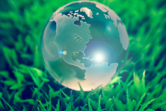 Crystal globe on green grass, with lens flare