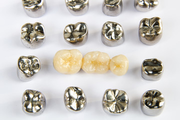 Dental ceramic, gold and metal tooth crowns on white background. Isolated.