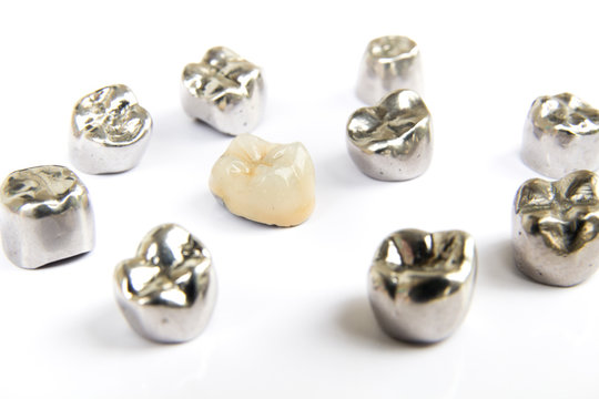 Dental ceramic, gold and metal tooth crowns on white background. Isolated.