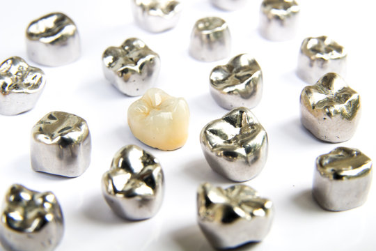Dental ceramic, gold and metal tooth crowns on white background. Isolated.