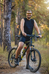 Obraz premium man cyclist rides forest paths