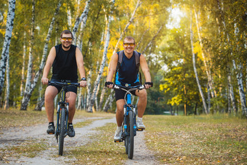 Two mountain bikers riding bike in the forest