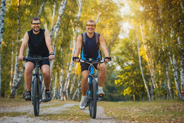 Two mountain bikers riding bike in the forest