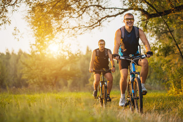 Fototapeta premium Two mountain bikers riding bike in the forest