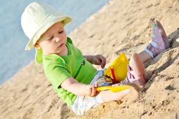Fototapeta na wymiar baby girl playing with sand