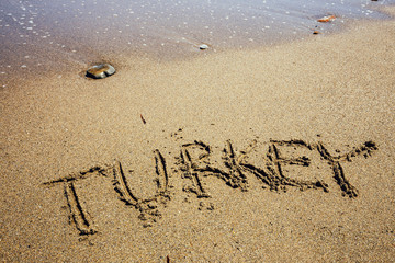 The word Turkey written in the sand on beach