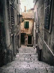 Old passage with stone stairs in Sibenik, Croatia. Filtered image.