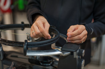 Stringing Machine. Close up of tennis stringer hands doing racket stringing in his workshop