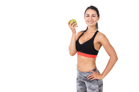 Smiling girl in sportswear with an apple