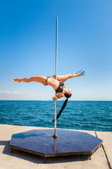 Female pole dancer against the sea and sky © Andriy Petrenko