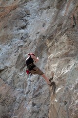 Woman climbing rock in Krabi, Thailand