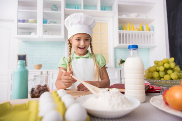 Pretty child cooking with enjoyment