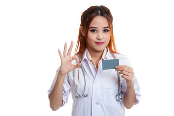 Asian young female doctor show Ok sign with blank card.