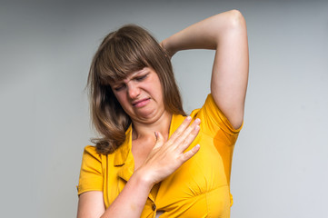 Woman with sweating under armpit in yellow dress