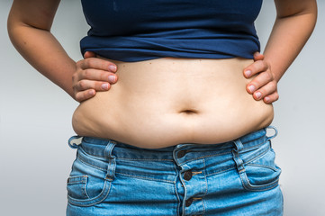 Overweight woman in jeans and fat on hips and belly