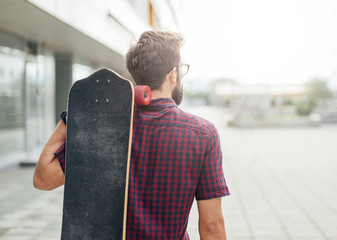 Man carrying skateboard on his back © yossarian6