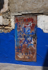 porte métallique rouillée sur vieille façade bleue