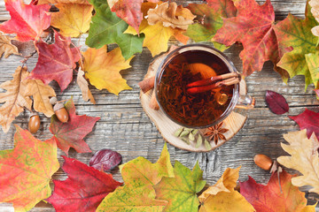 tea cup and autumn leaves on a wooden background