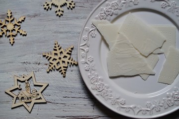 Traditional Christmas wafer on a wooden table on a white plate
