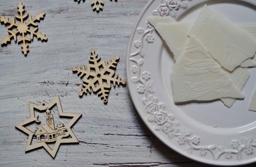 Traditional Christmas wafer on a wooden table on a white plate
