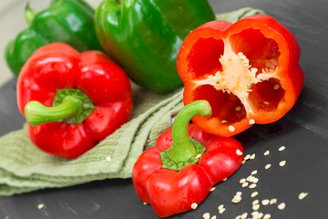 fresh red and green bell pepper with seeds being cut on wood board