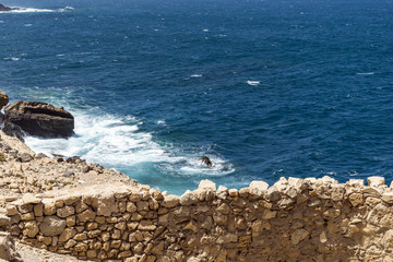 Daylight scene taken in a fischer vilage called Ajuy, located on the western coast of Fuerteventura, Spain. Very intensive blue color of the ocean with white foam hitting some rocks on the coast.