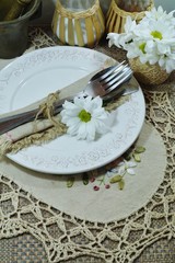 Festive table in folk style - a plate, cutlery and flowers on the table 