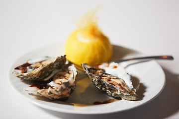 Fresh oysters platter with sauce and lemon
