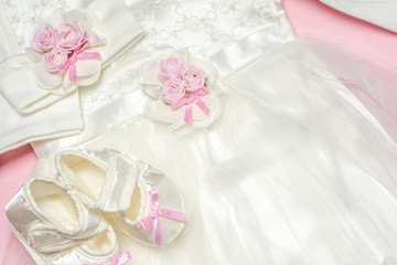 Clothes for baby girl on a pink background. Copy space