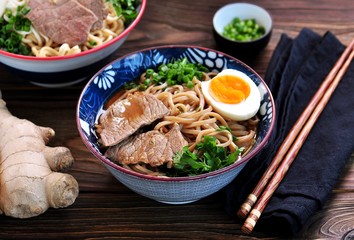 Soup with soba and ramen noodles, beef, ginger, green onions and egg.