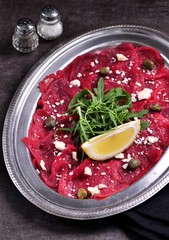 Beef carpaccio with capers, parmesan, arugula, lemon and olive oil.