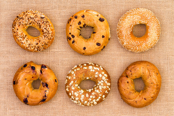 Six different tasty fresh bagels on burlap