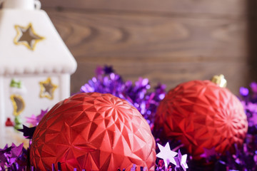 Christmas red balls , tinsel and candle holder house on wooden background.Merry Christmas and happy New Year.