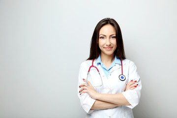 Portrait of young medical doctor on a grey background