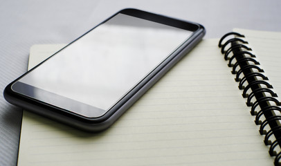 Smartphone on notebook with space on white background