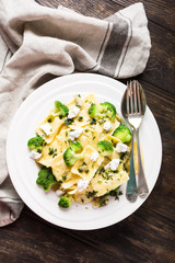 Italian ravioli with goat cheese, broccoli and herbs on old wooden background. Healthy food. Top view.