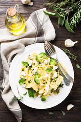 Italian ravioli with goat cheese, broccoli and herbs on old wooden background. Healthy food. Top view.