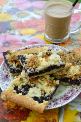 Delicious piece of dessert with blueberries on a plate and cup of coffee.