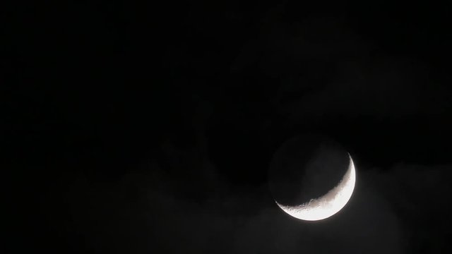 In night sky seen crescent and passing clouds. A scenic view of heaven
