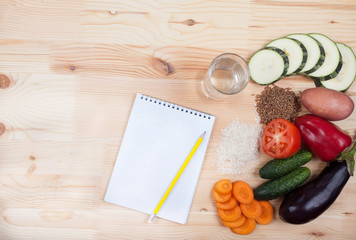 vegetables and cereals and notebook on a wooden table. Healthy E
