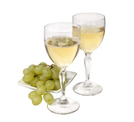 two glasses of sparkling white wine. green grapes on a white plate. isolated on white background